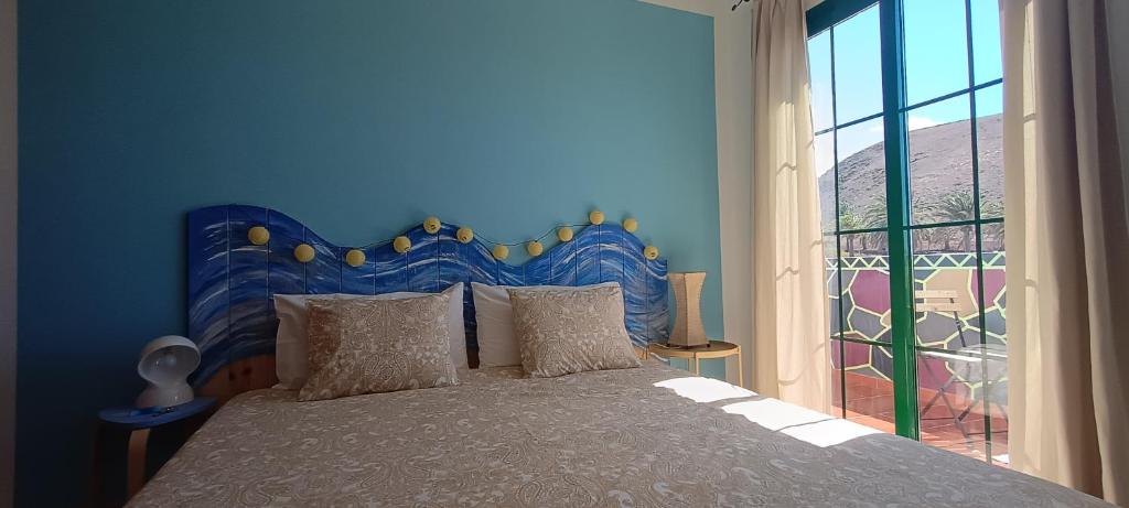 亚伊萨Casa Luz的蓝色的卧室设有床和大窗户