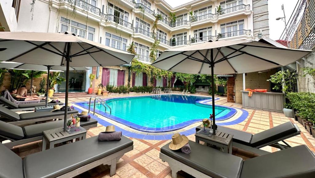 暹粒暹粒回忆酒店的一座带遮阳伞的建筑的庭院内的游泳池