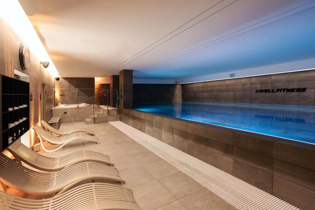 弗罗茨瓦夫弗罗茨瓦夫希尔顿逸林酒店的一个带长椅的游泳池