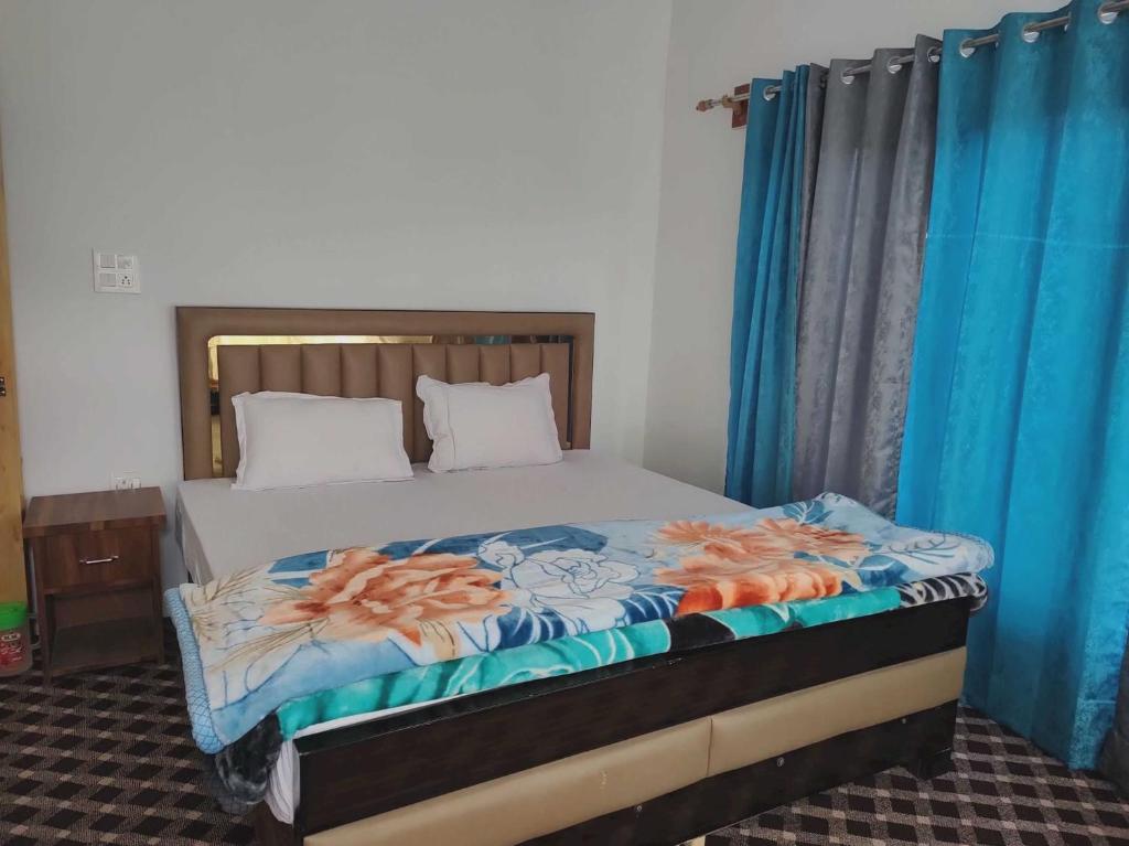 努布拉POP HOME 81129A Skayil Guest House的一张位于带蓝色窗帘和西德西德床的房间的床位