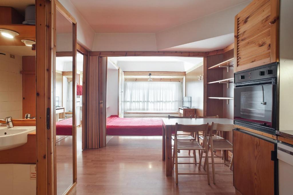 马里尔伊瓦Artuik Appartamenti Montana的一间厨房、一间带桌子的用餐室和一间卧室