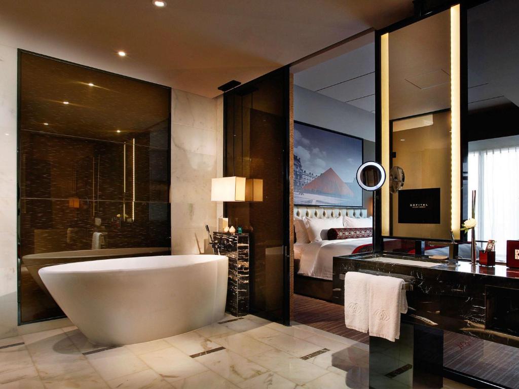 广州Sofitel Guangzhou Sunrich的带浴缸的浴室和卧室