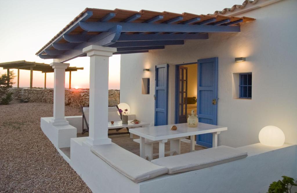 拉萨维纳Cas Saliners - Villa Can Paya的白色的房子,设有蓝色的门和一张桌子