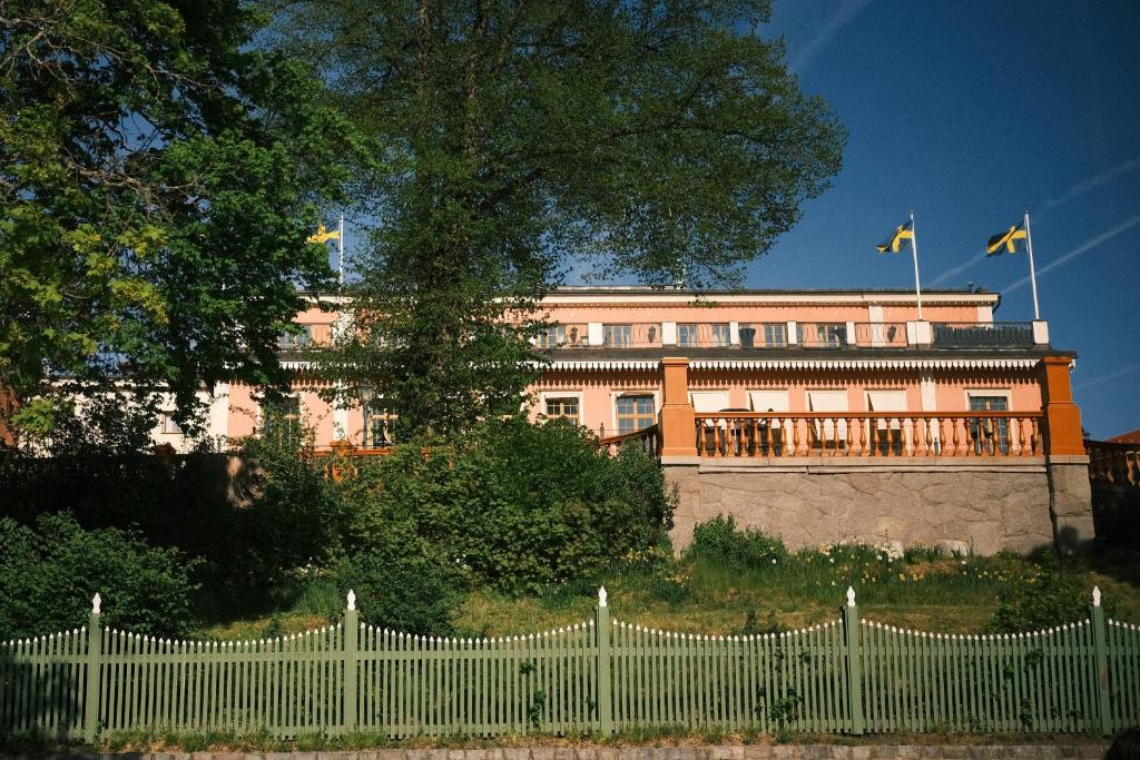 斯德哥尔摩Hotel Hasselbacken的建筑前的白色栅栏,有旗帜