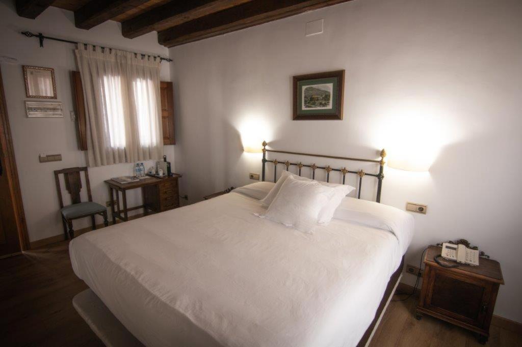 夸科斯德尤斯特亚巴迪亚德乌斯特乡村酒店 的卧室配有一张白色的大床和一张桌子