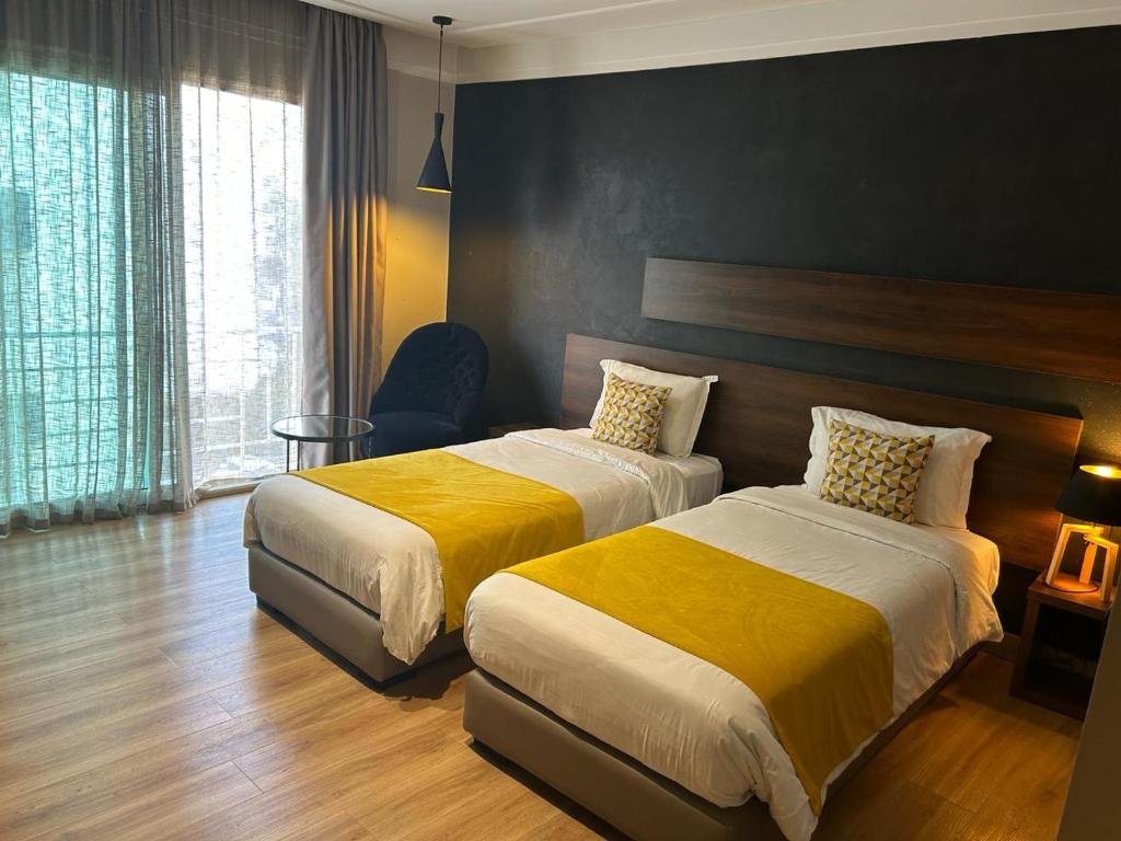 卡萨布兰卡Yto boutique Hotel的酒店客房带两张带黄床单的床