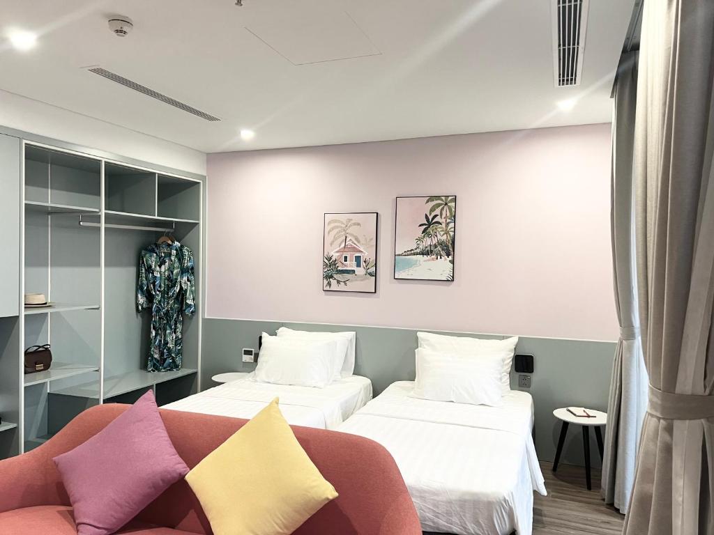 Nam KhêCăn hộ condotel Ibiza Hải Tiến的酒店客房,设有两张床和一张沙发