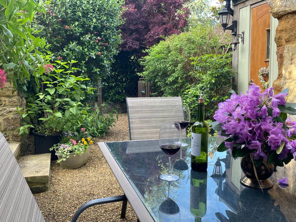 ChideockThe Burrow的一张桌子,上面放着两杯葡萄酒和紫色的鲜花