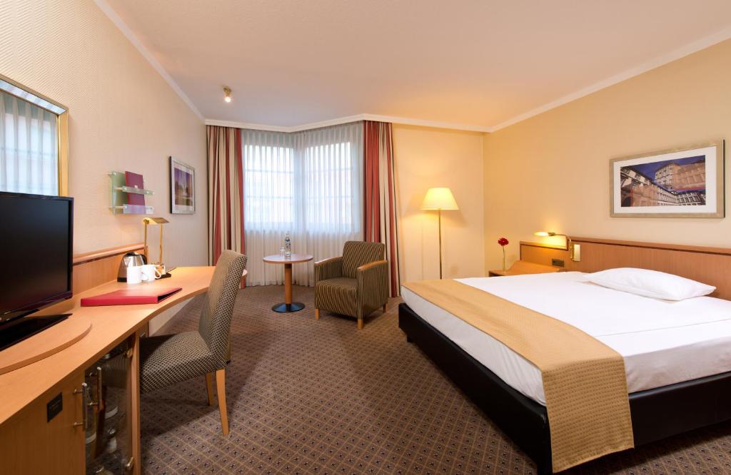 曼海姆曼海姆市中心莱昂纳多酒店的配有一张床和一张书桌的酒店客房