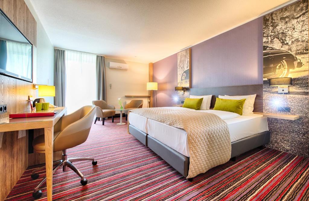 沃尔夫斯堡沃尔夫斯堡市中心莱昂纳多酒店的配有一张床和一张书桌的酒店客房