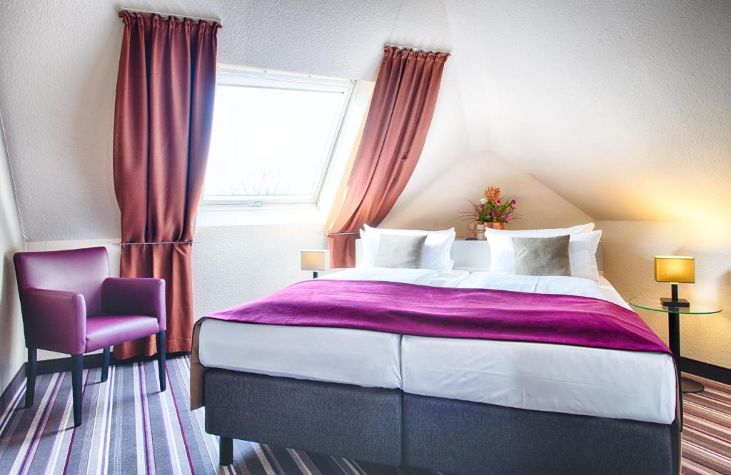 拉登堡曼海姆-拉登堡莱昂纳多酒店的一间卧室设有一张大床和一个窗户。