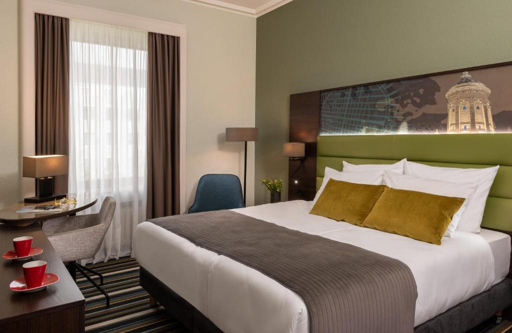 曼海姆莱昂纳多皇家曼海姆酒店的酒店客房设有一张大床和一张书桌。