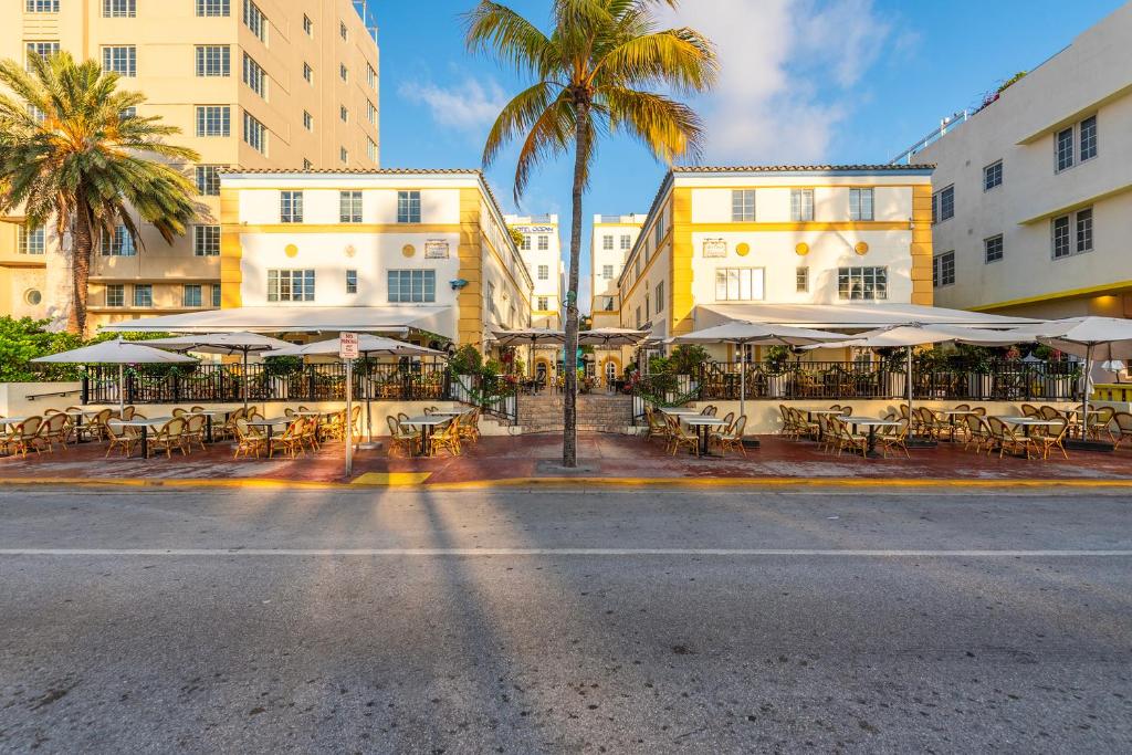 迈阿密海滩海洋酒店 的一条空的街道,上面有桌子和伞,还有建筑