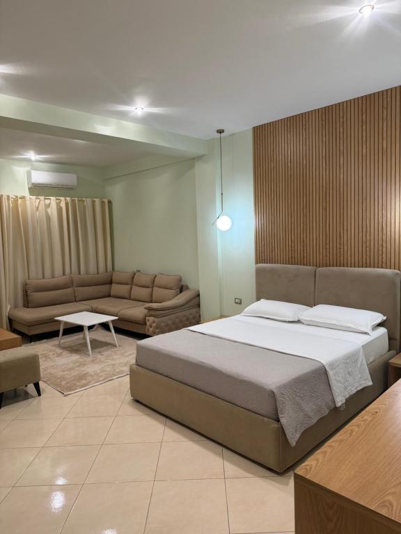 地拉那Hotel Kaloshi的一间卧室配有一张大床和一张沙发