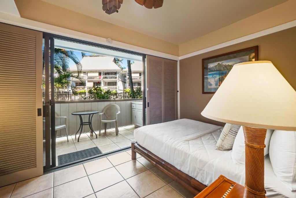 希洛Waiakea Villas 4-124的一间卧室配有一张床,阳台配有桌子