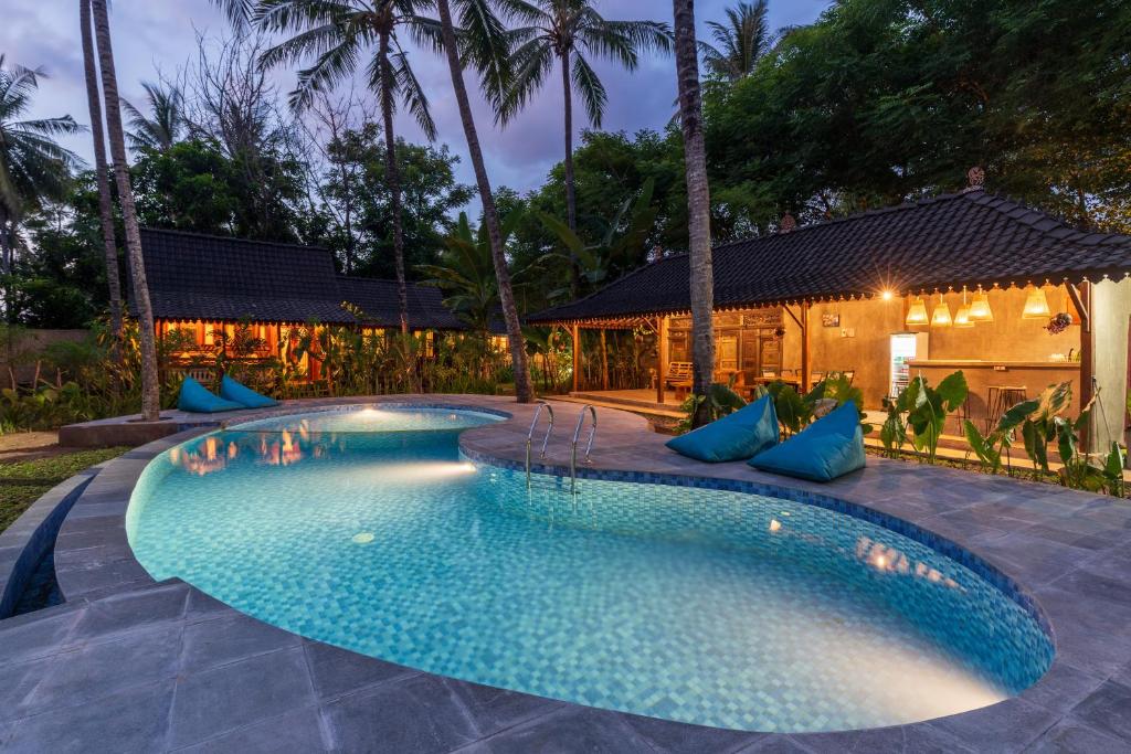 SorongjukungTahlia's Villa的旁边一座带蓝色枕头的游泳池