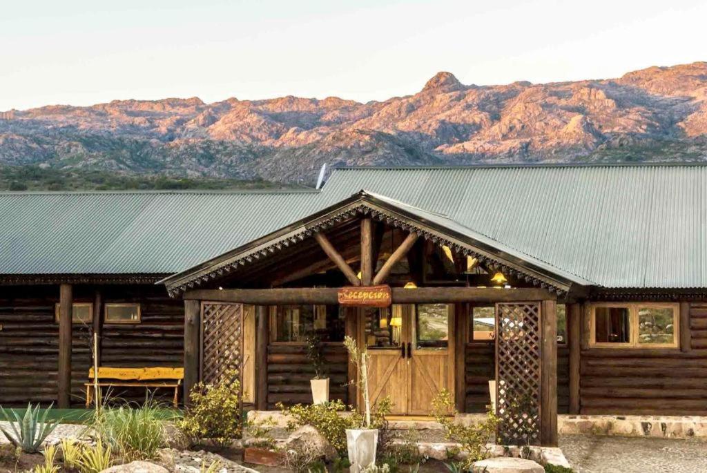 米娜克拉韦罗洛杉安卡雷斯度假村的小木屋拥有绿色屋顶和山脉背景