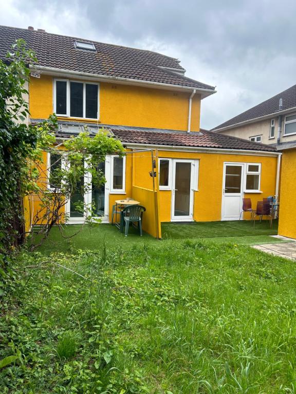 剑桥Blissful 1-bedroom entire place的前面有草坪的黄色房子