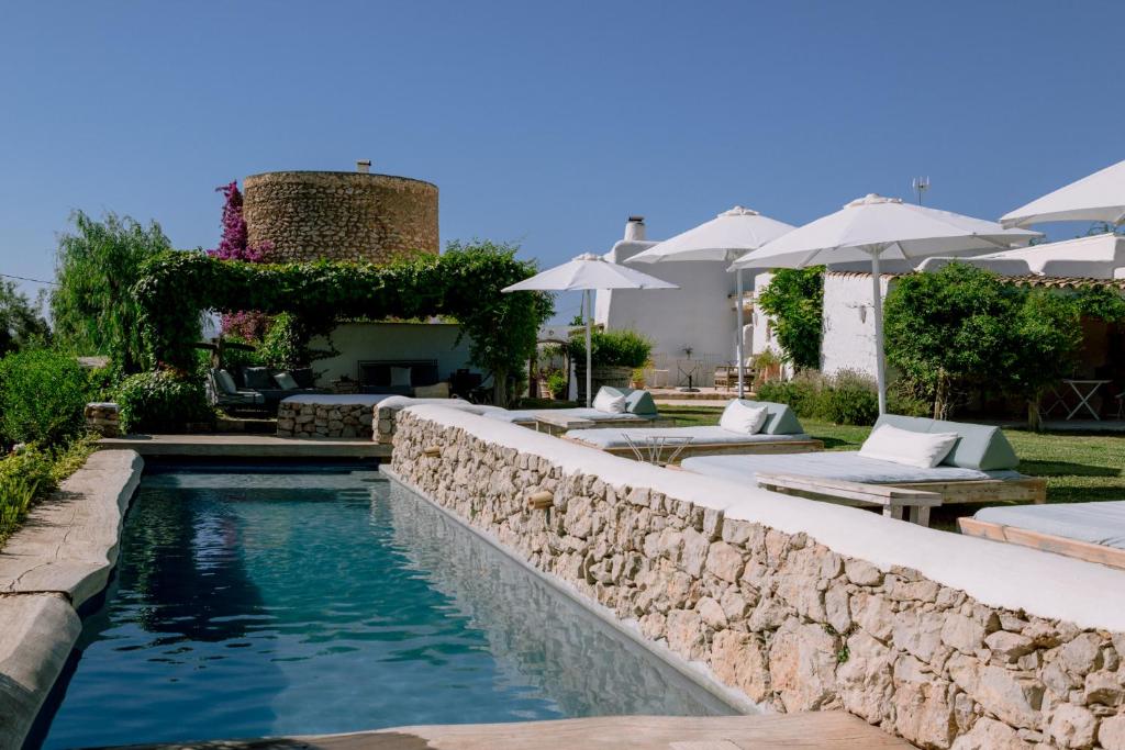 圣洛伦索巴拉菲Can Quince de Balafia - Turismo de Interior的一座房子旁的游泳池,游泳池旁设有石墙