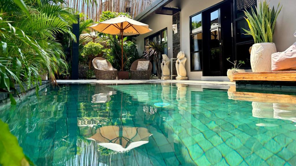 吉利特拉旺安Amalika Private Pool Villa Central to Everything的一座带遮阳伞的游泳池