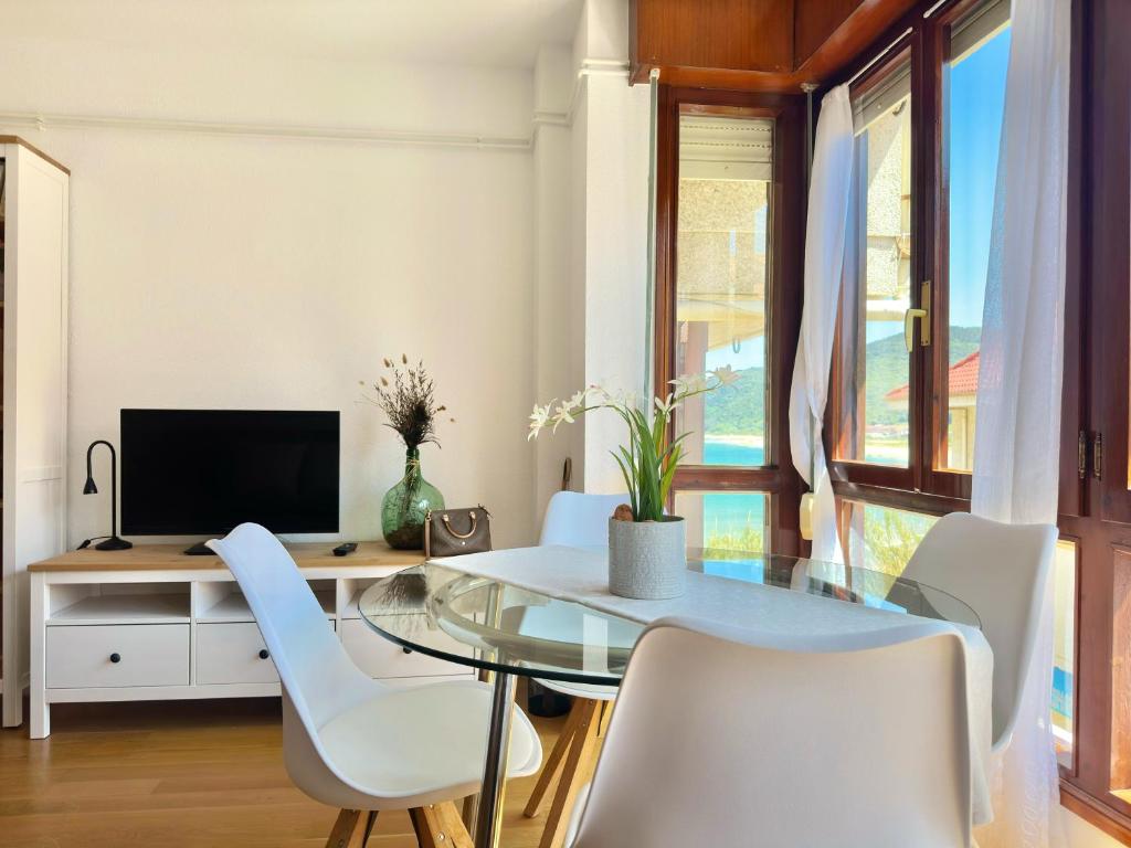 诺哈El Camarote - 6019的一间设有玻璃桌和白色椅子的用餐室