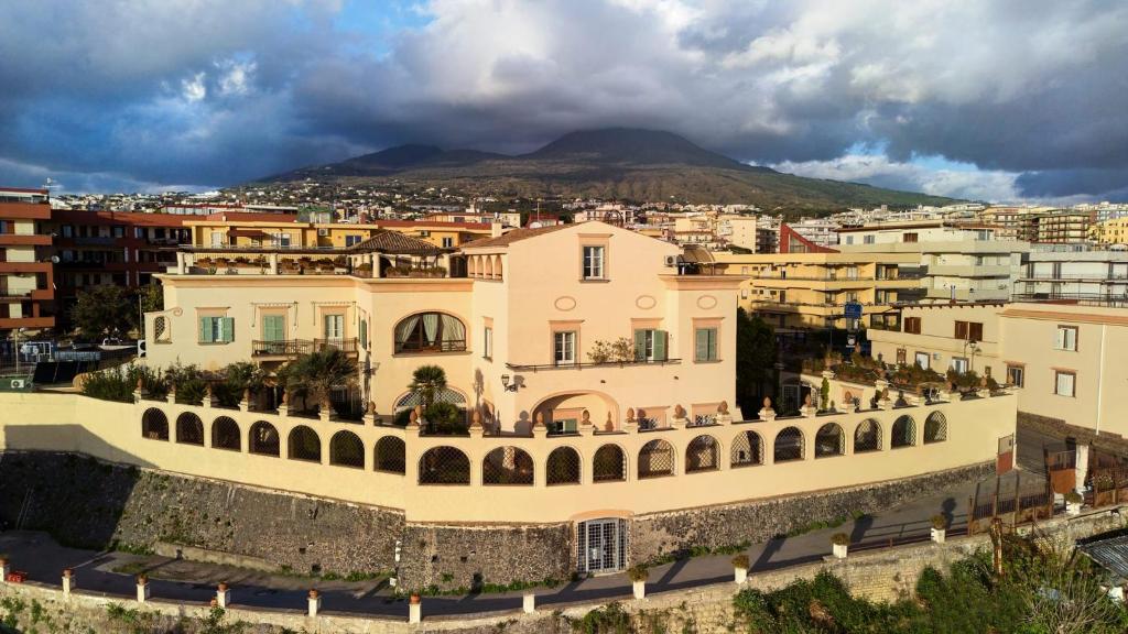 埃尔科拉诺Casa Raiola Ercolano Luxury Rooms &amp; Spa的一座以山为背景的城市中的建筑