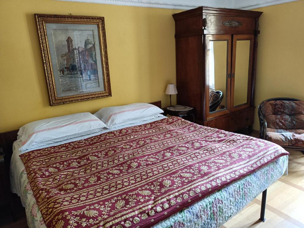 瓦伦纳Villa Torretta的卧室配有一张床,墙上挂着一幅画