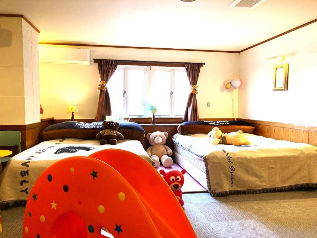 涩川市Ikaho Kids Paradise Hotel - Vacation STAY 56430v的一间卧室设有两张床,里面饲养着动物。
