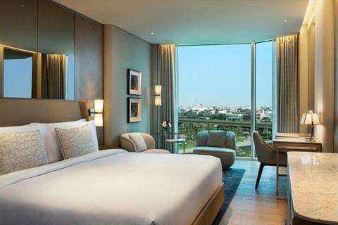 新德里Rosewood Suites Near IGI Airport的酒店客房设有一张床和一个大窗户
