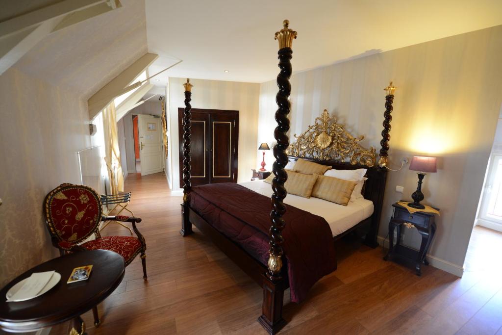 查姆布里陶德博伊斯涅德城堡酒店的一间卧室配有一张天蓬床和一把椅子