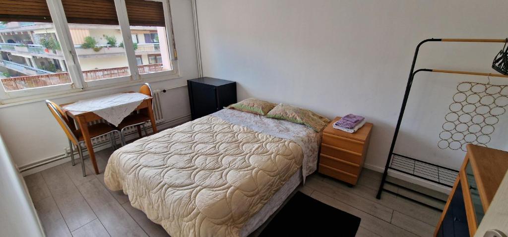 安纳马斯Chambre double privée, Appartement partagé的一间卧室配有一张床、一张桌子和一个窗户。