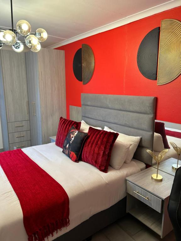 布隆方丹SiBella guest house的一间卧室配有一张红色墙壁的床