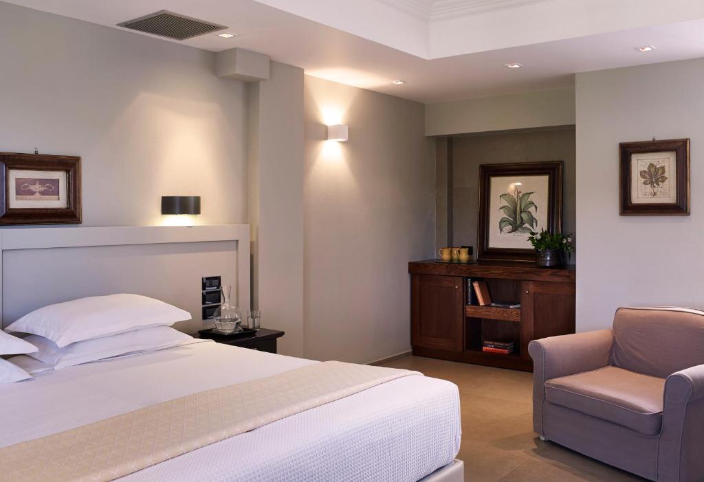 塞沃塔多莫特贴水尼古拉斯套房度假酒店的卧室配有白色的床和椅子