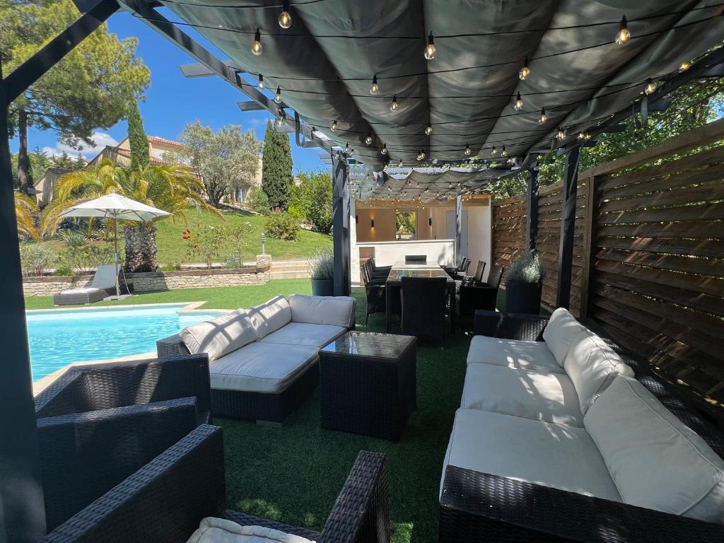 RoussasLe Mas de l'Alliance - 12 p - Air Cond - private Pool - near Grignan的带沙发的庭院和游泳池