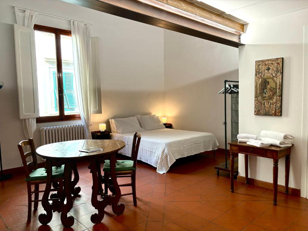 佛罗伦萨Affittacamere Medusa的卧室配有一张床和一张桌子及椅子
