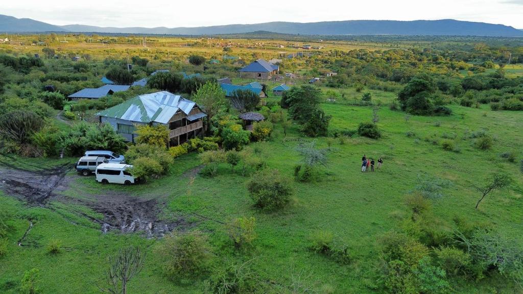 OlolaimutiekEco mara forest camp的空中景色,在田野停泊车辆的农场