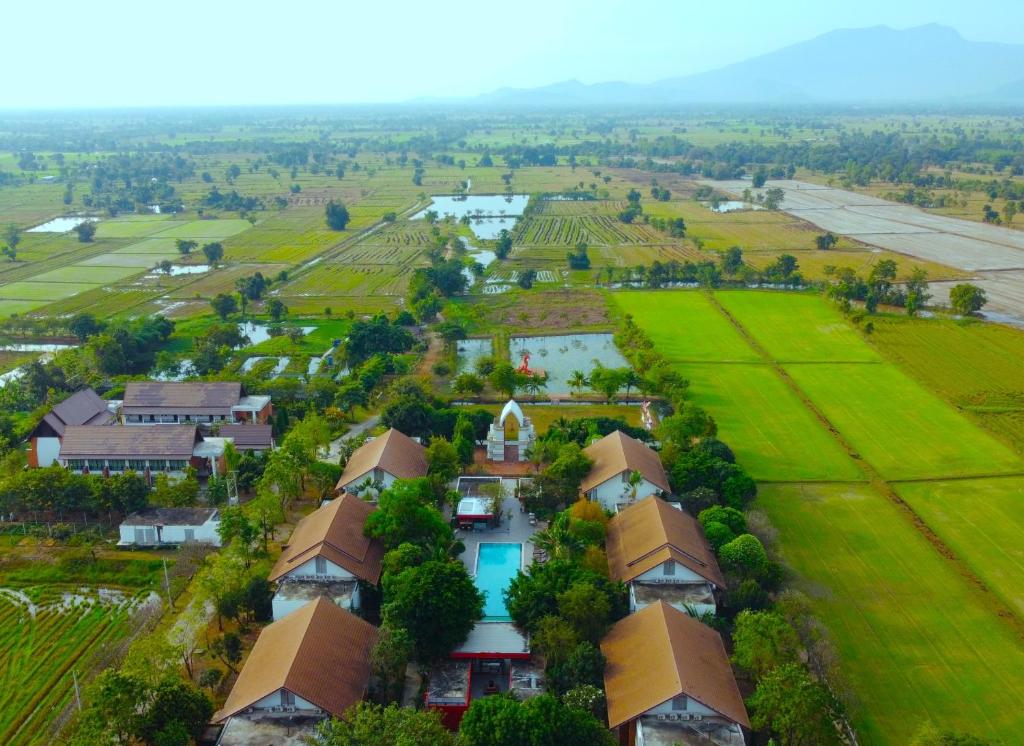 素可泰Sukhothai Treasure Resort & Spa- SHA Plus Certified的享有村庄的空中景致,设有房屋和田野