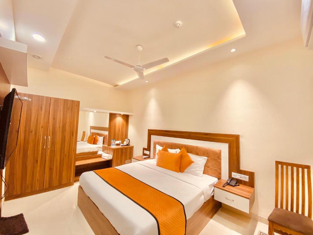 阿姆利则Hotel White house near Golden Temple的一间卧室配有一张带橙色枕头的大床