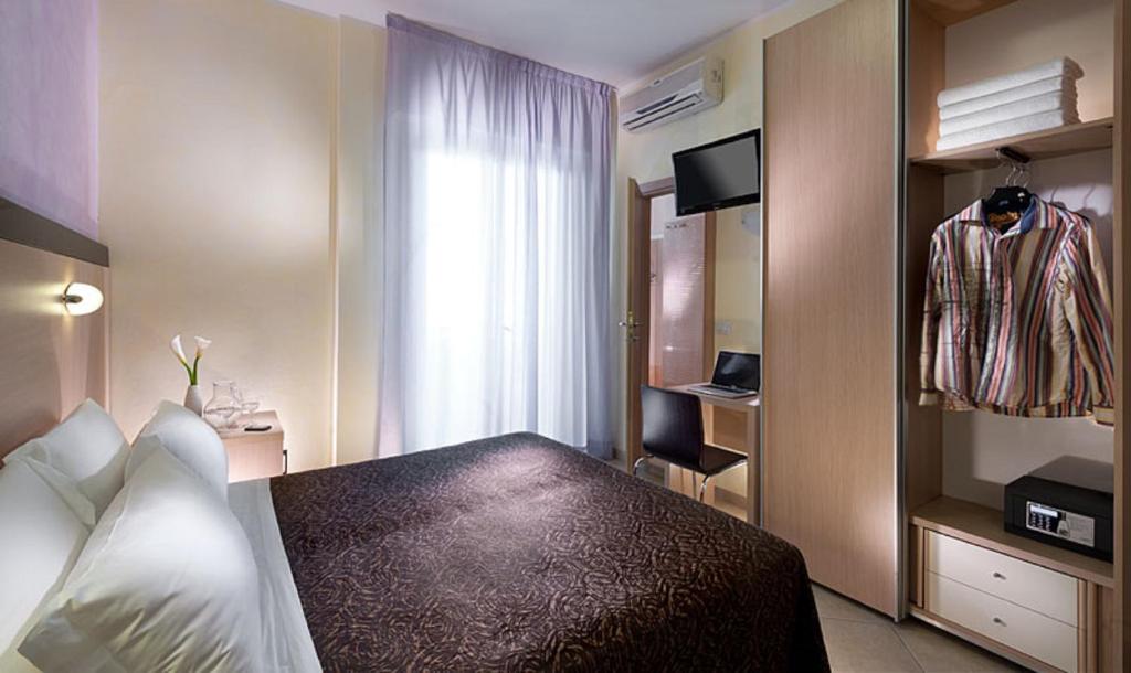 里米尼鲁宾斯酒店的酒店客房,配有床和电视