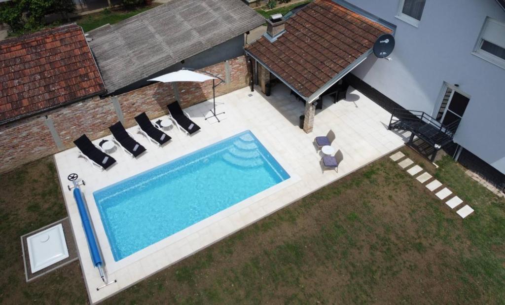 KaranacVilla Sorella Baranja的享有带椅子的游泳池和房屋的顶部景致