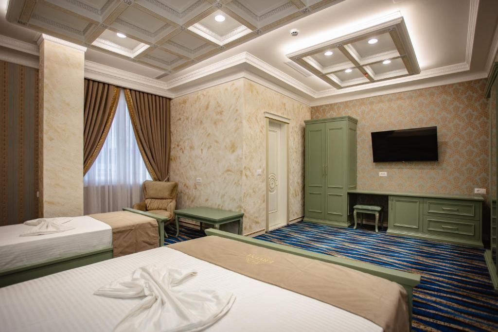 斯库台Ervini Boutique Hotel的酒店客房设有两张床和电视。