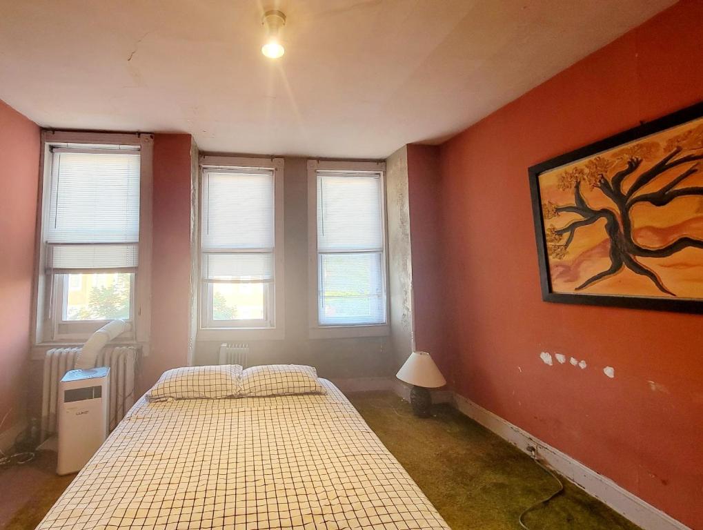 巴尔的摩Room in Vintage House near Downtown w Free Parking的宿舍间的两张床,设有红色的墙壁和窗户