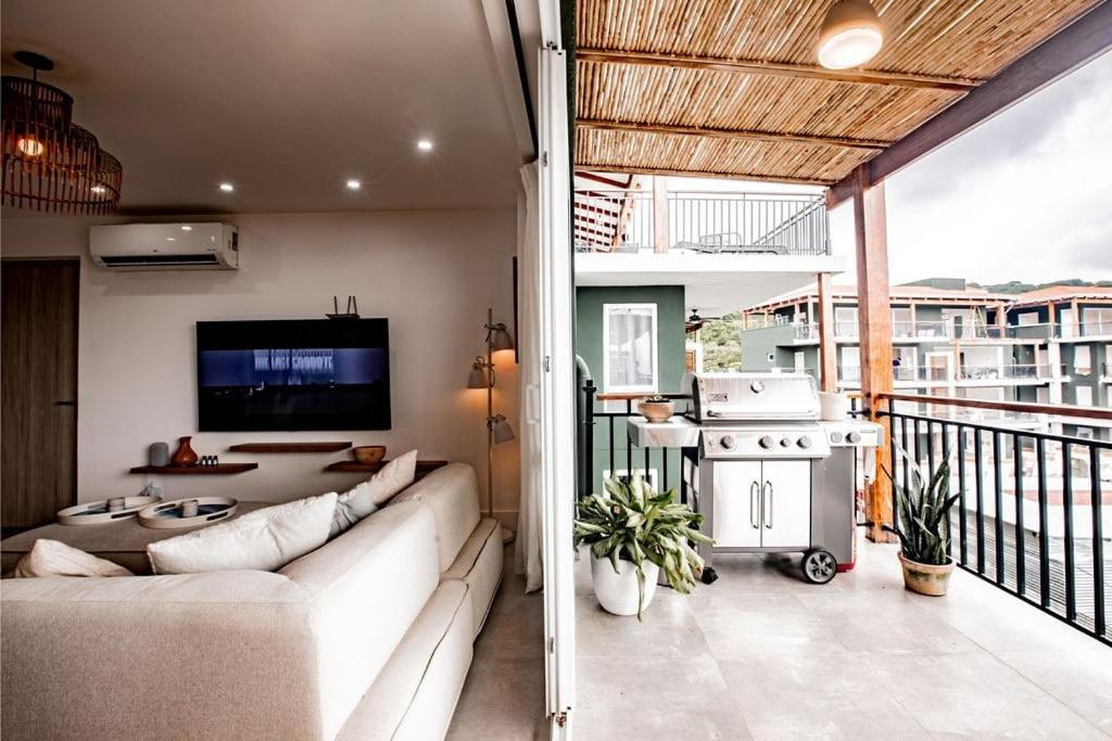 普拉纳维瑙Blue Venao CONDO APARTMENT C32的客厅配有沙发,阳台上配有电视。