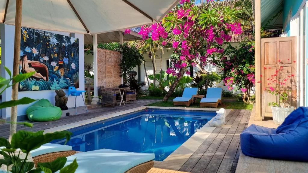 沙努尔Starling villas的一个带椅子和遮阳伞的游泳池