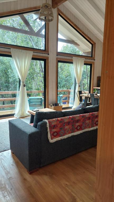 普孔Tres Bosques的带沙发和大窗户的客厅