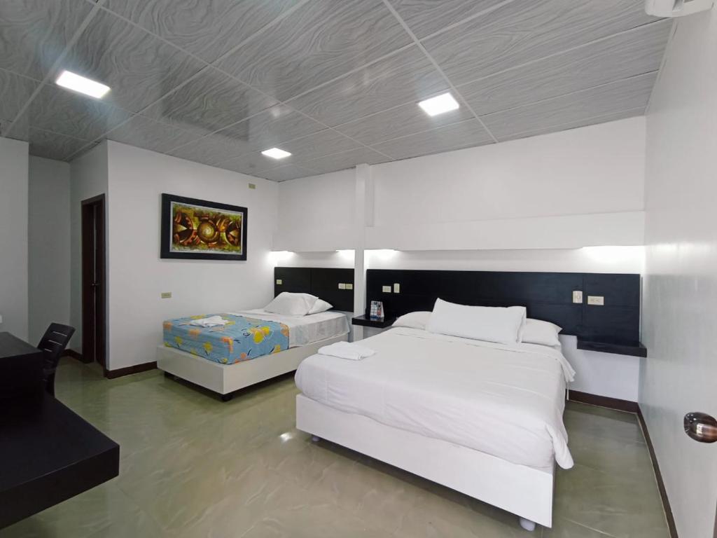 巴克里索莫雷诺港洛斯阿尔加鲁博斯旅舍的一间大卧室,配有两张床和一张桌子