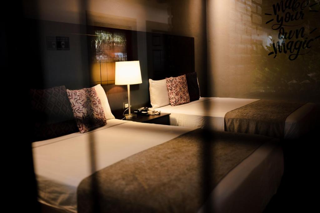 MocoritoPunto Madero Hotel & Plaza的酒店客房,设有两张床和一盏灯