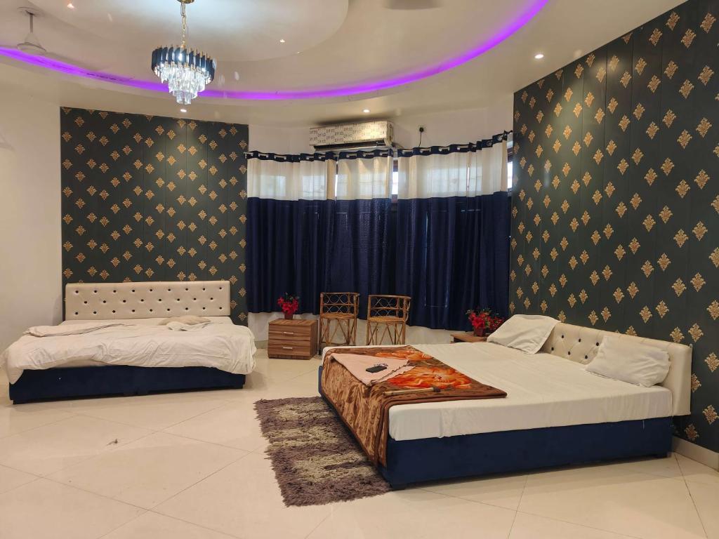 PrayagrajMauji's Villa Hotel & Guest House的一间卧室配有两张床和吊灯。