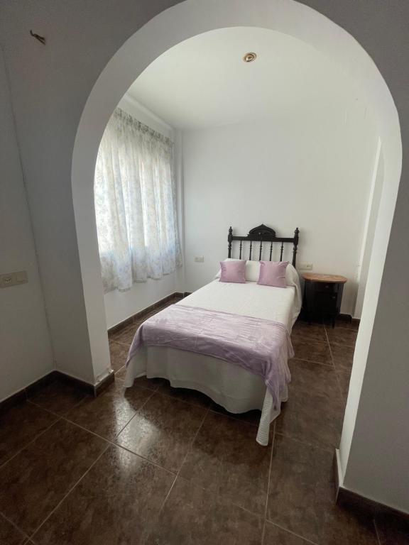 BenifalletLo Jardí de Benifallet的白色卧室配有带粉红色枕头的床