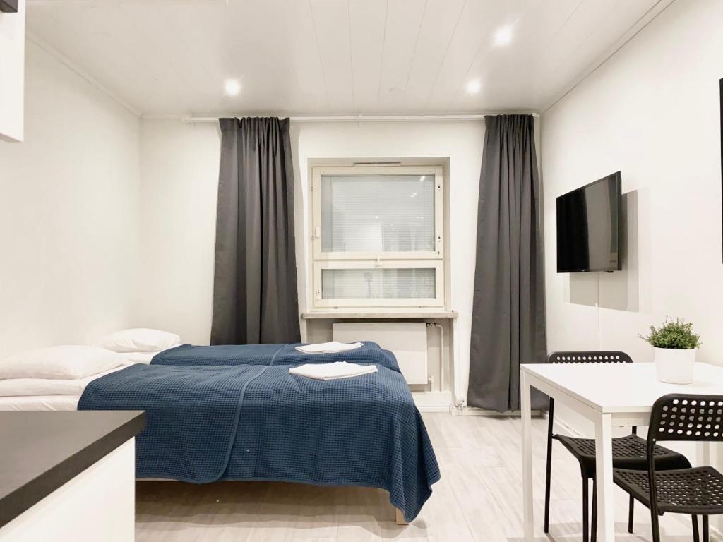 波里City Center Studio Pori的一间卧室配有一张床、一张桌子和一台电视